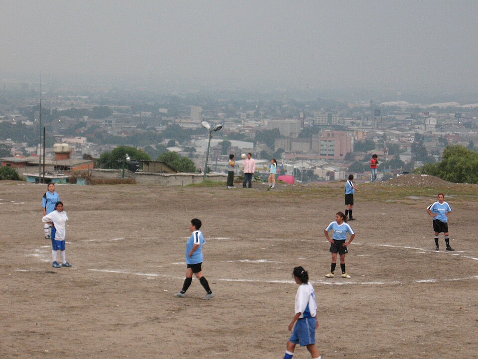 Jugadores preparándose para un saque de esquina en un estadio de fútbol