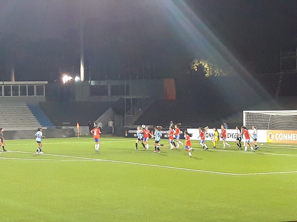 Jugador a punto de ejecutar un tiro de esquina en un partido nocturno