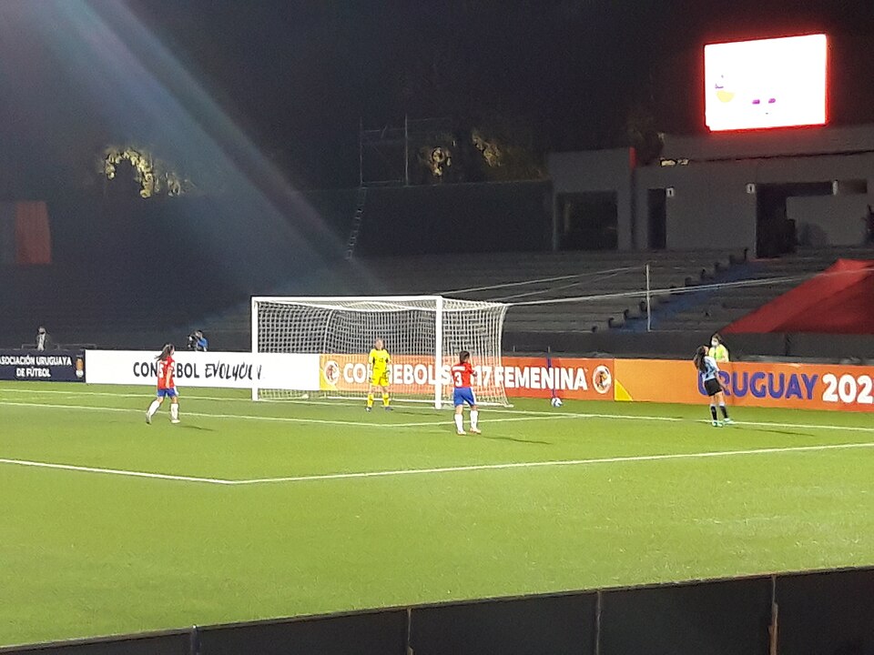 Jugador lanzando un saque de esquina en un partido de alta tensión